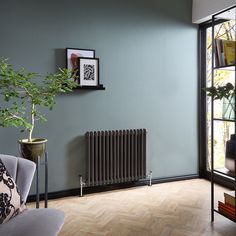 a living room with a radiator, chair and potted plant