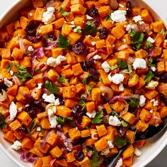 a white bowl filled with sweet potatoes and feta cheese