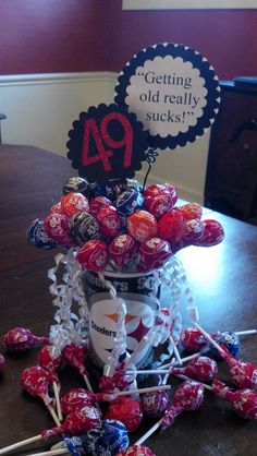 an arrangement of candies on a table with a sign saying getting old really sucks