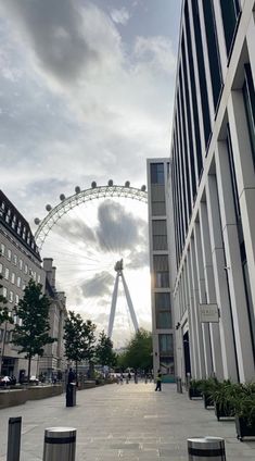 the london eye is in the distance behind some buildings