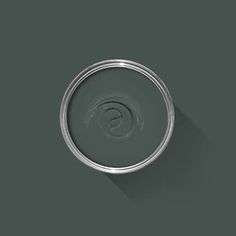 a can of paint with a shadow on the wall in front of it and a green background