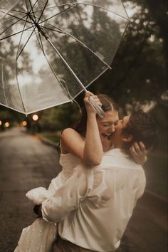 a couple kissing under an umbrella in the rain