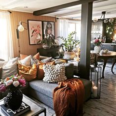 a living room filled with lots of furniture and flowers on the table in front of it