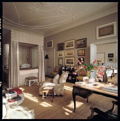 a living room filled with furniture and pictures on the wall next to a bed in a bedroom