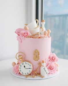 there is a pink cake with flowers on the top and a clock in the middle