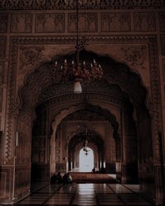 an ornate hallway with chandelier and marble flooring in the middle of it