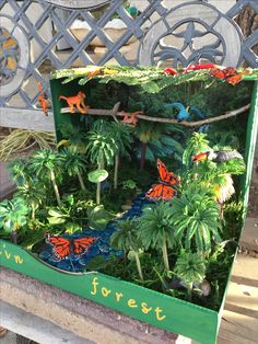 a green box filled with lots of different types of plants and animals on top of it