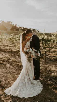 a bride and groom kissing in the vineyard