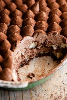 a half eaten chocolate cake sitting on top of a wooden table