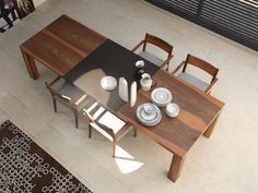 an overhead view of a dining table with chairs and vases on the table top