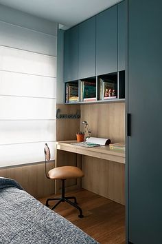 a bedroom with a bed, desk and bookshelf next to a window in the room