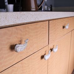 a wooden cabinet with metal knobs on it's drawers in a home kitchen