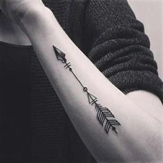 a woman's arm with an arrow tattoo on it