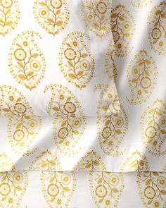 the white and gold fabric has an intricate design on it's side, as well as two matching sheets