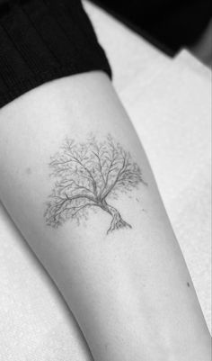 a woman's arm with a tree tattoo on the left side of her body