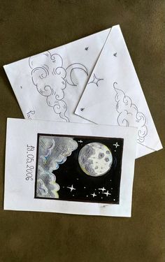 three envelopes with drawings on them and one has a drawing of the moon in the sky