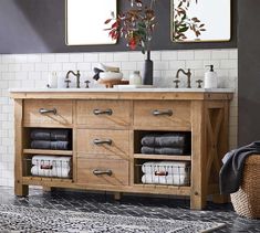 a bathroom vanity with two mirrors above it and towels on the counter top in front of it