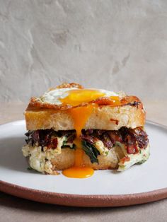 an egg and bacon sandwich is on a plate