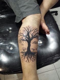 a man with a tree tattoo on his leg