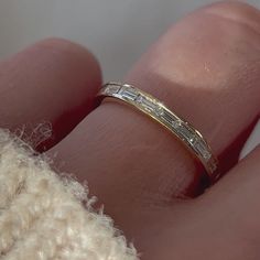 a close up of a person's hand with a wedding ring on their finger