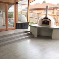 an outdoor pizza oven in the middle of a patio area with steps leading up to it