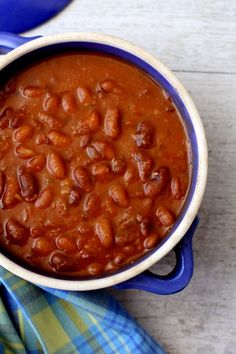 a blue pot filled with beans sitting on top of a table