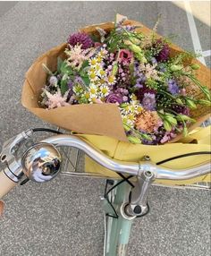 a bunch of flowers sitting on the back of a bike