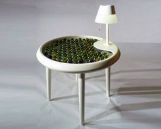 a table that has some bottles on it and a lamp next to it in the shape of a circle