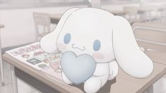 a white rabbit sitting on top of a wooden table next to a book with a blue heart