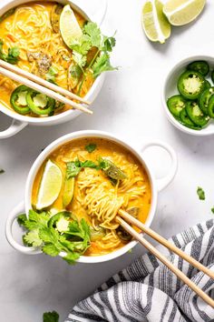 two bowls of soup with chopsticks on the side