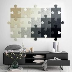 a large piece of puzzle sitting on top of a tv stand next to a vase