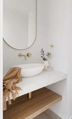 a bathroom with a sink, mirror and towel on the counter in front of it