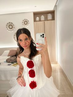 a woman in a white dress is holding up her cell phone to take a selfie