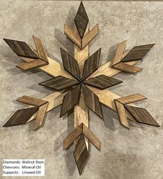 a wooden snowflake sitting on top of a cement floor next to a wall