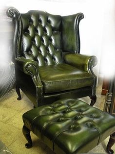 a green leather chair and ottoman in a room