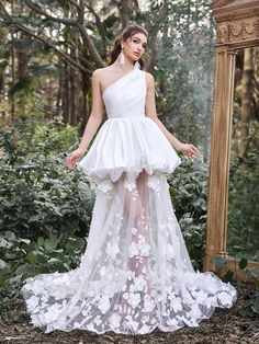 a woman in a white dress standing next to a mirror