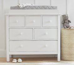 a baby crib next to a white dresser