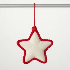 a red and white star hanging from a metal pole with a string attached to it