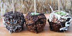 three chocolate covered donuts sitting on top of a wooden cutting board