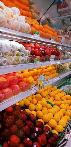 an assortment of fruits and vegetables on display in a grocery store