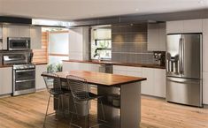 a modern kitchen with stainless steel appliances and wood flooring