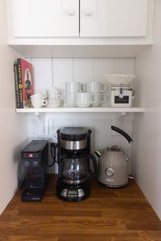 there is a coffee maker and other items on the shelf in this kitchen cupboards