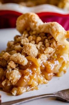 a piece of apple crisp pie on a plate with a fork and spoon next to it