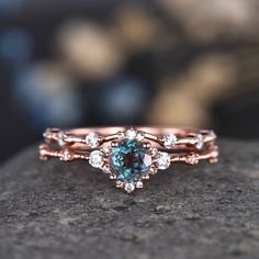 a blue diamond ring sitting on top of a rock