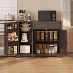 a microwave sitting on top of a wooden cabinet next to a shelf filled with food