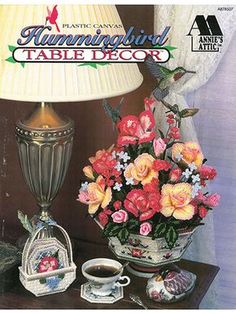 the cover of a book with flowers and other items on it, next to a lamp