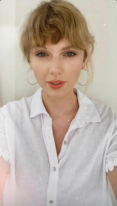 a woman with short hair wearing a white shirt