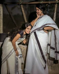 two women dressed in sari standing next to each other