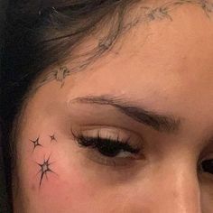 a close up of a person's face with stars on their forehead and behind her ear