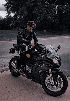 a man sitting on top of a black motorcycle